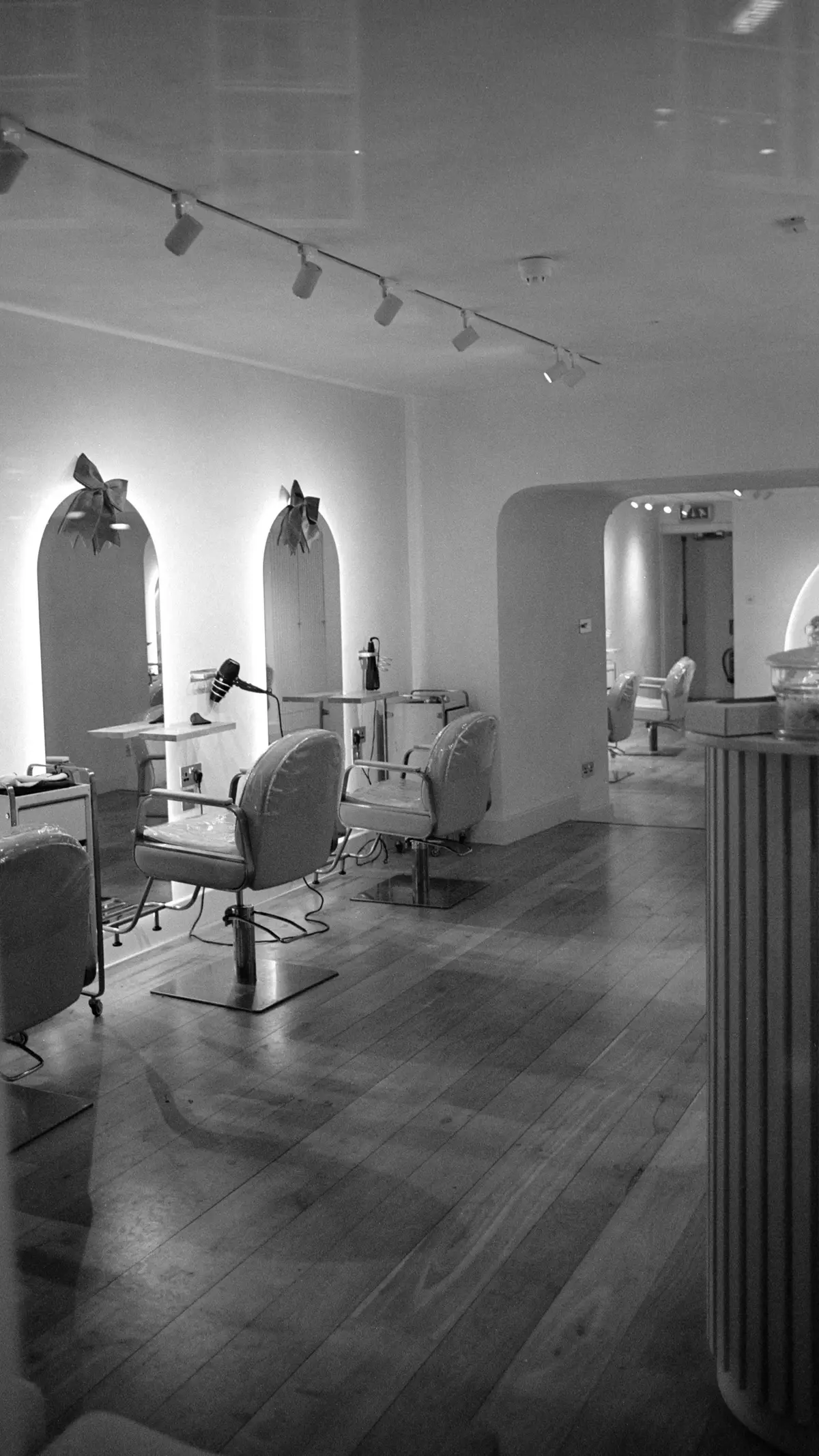 Bright salon with styling chairs and arched mirrors