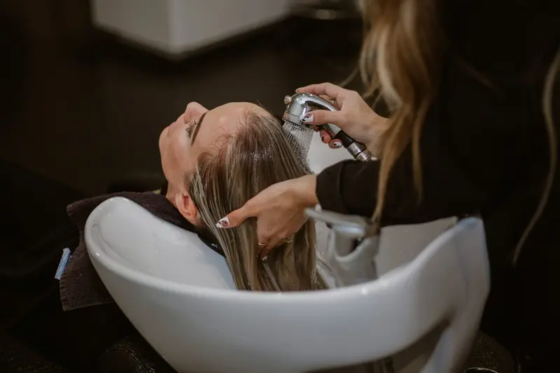 Client relaxing during a hair wash at a salon