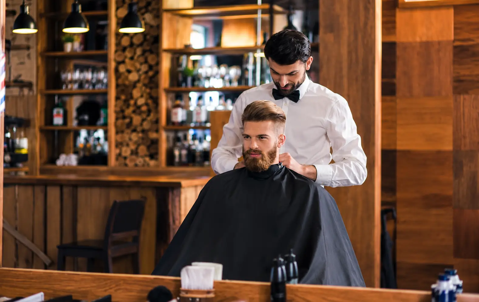 Barber styling a client's beard in a classic barbershop