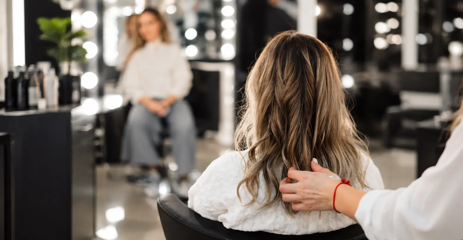 Stylist preparing a client's long hair in a modern salon